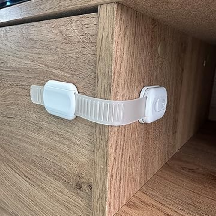 White adhesive strap latch fitted around the corner of a wood-grain drawer