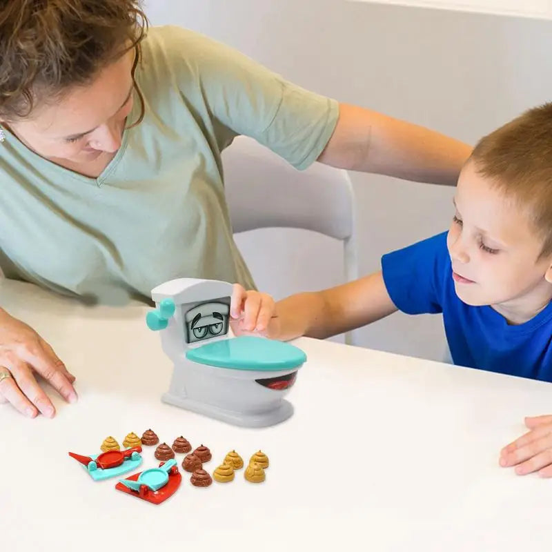Adult and child playing with the toilet target, two catapults, and poop-shaped pieces