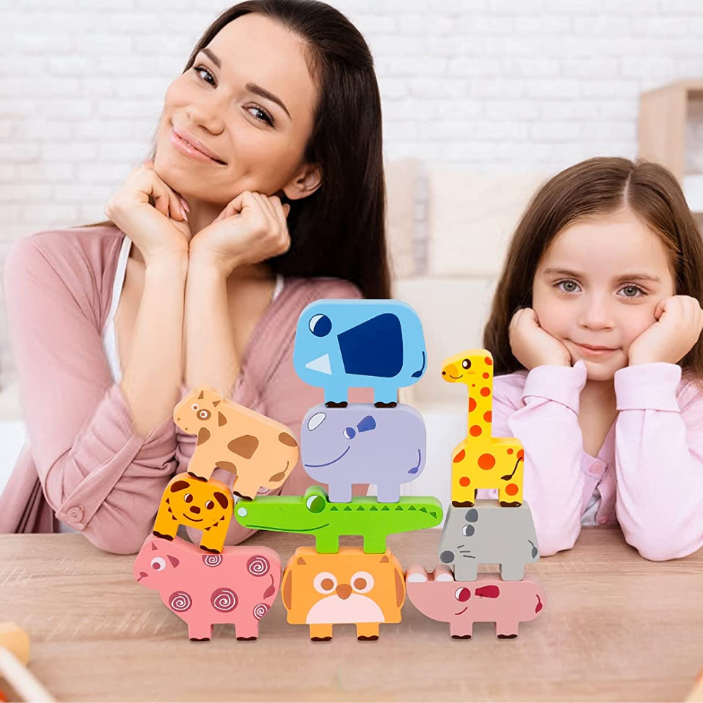 Adult and child seated behind a balanced arrangement of wooden animal blocks