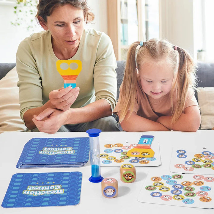 Adult and child playing an animal-matching card game with paddles, dice, and an hourglass