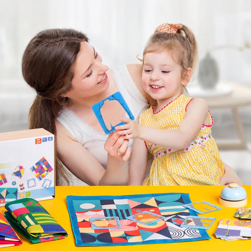 Adult and child holding a clothing-shaped card frame beside the colorful pattern-matching game.