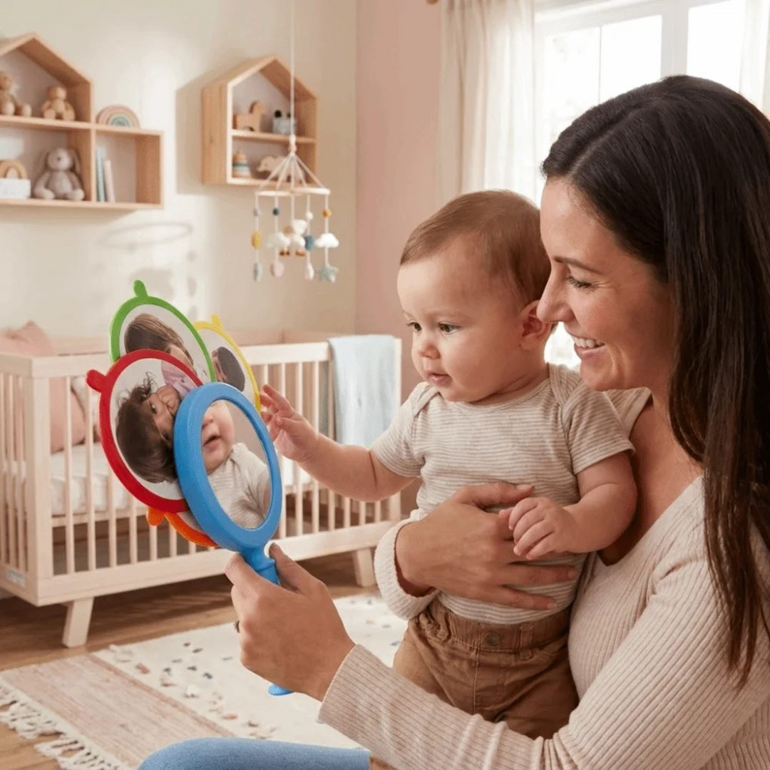 Adult sharing a handheld expression mirror with a child