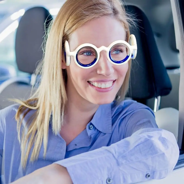 Adult wearing white motion sickness glasses inside a car