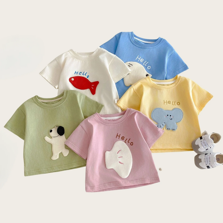 Five cartoon patch T-shirts arranged with a small plush toy