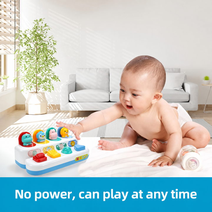 Baby reaching for the animal pop-up activity toy on a bed