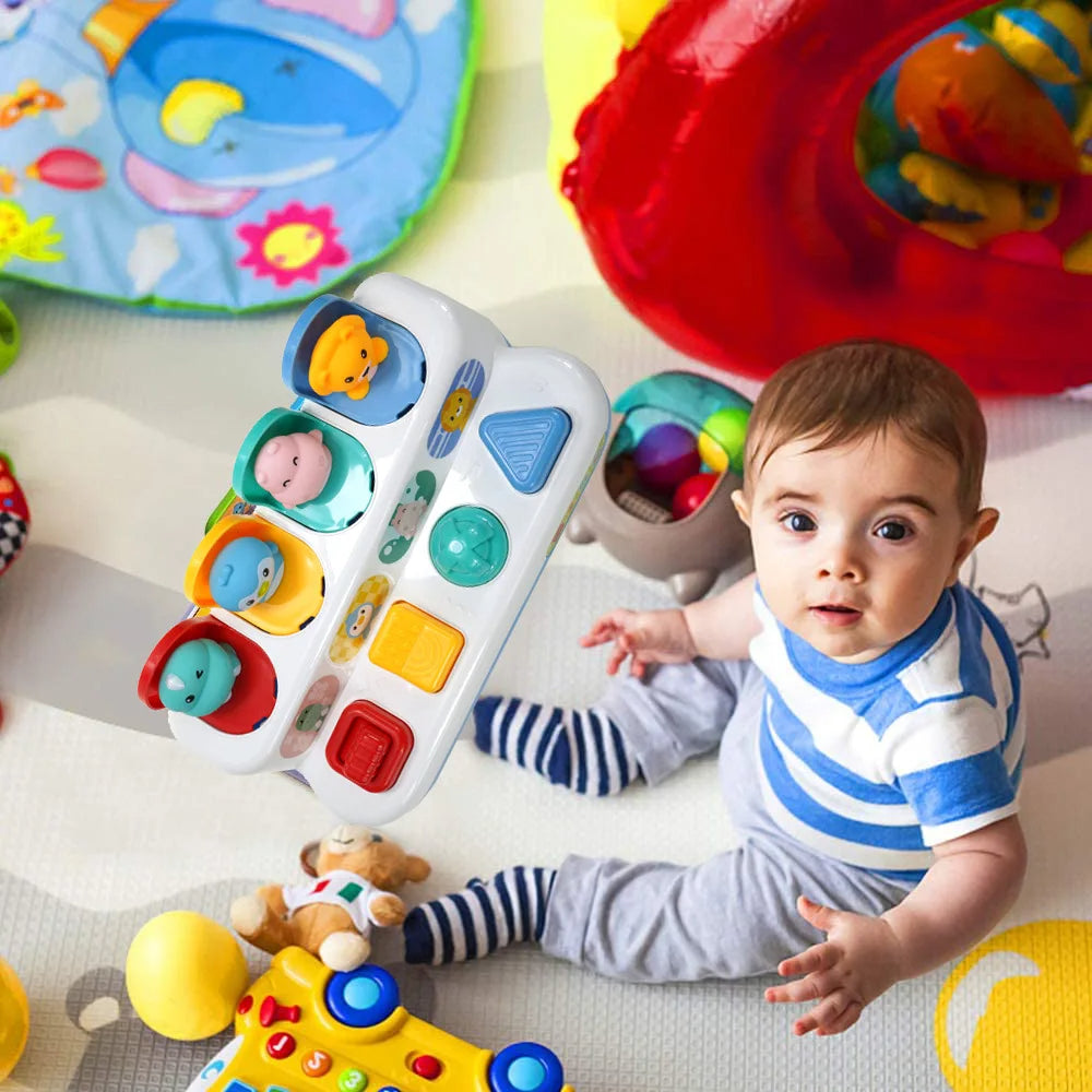 Baby sitting beside an animal pop-up activity toy with four colorful controls
