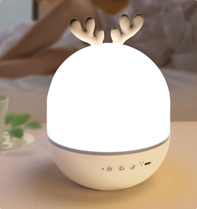 Antler-style night light with a white dome glow on a bedside table