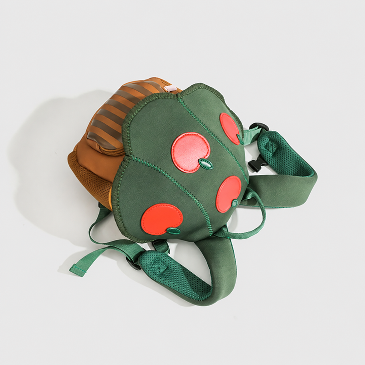 Apple Tree backpack lying flat with its green shoulder straps and carry handle visible.
