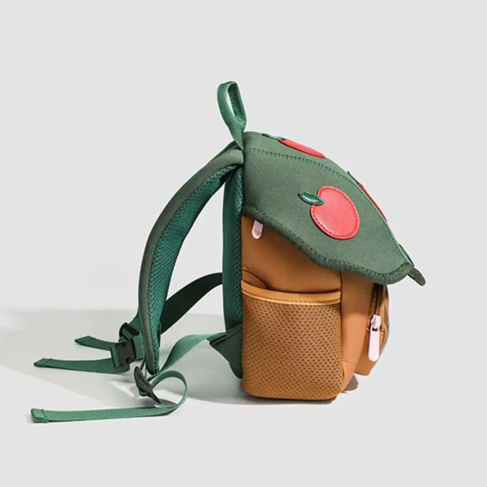 Side profile of the Apple Tree backpack showing its mesh pocket and green shoulder straps.