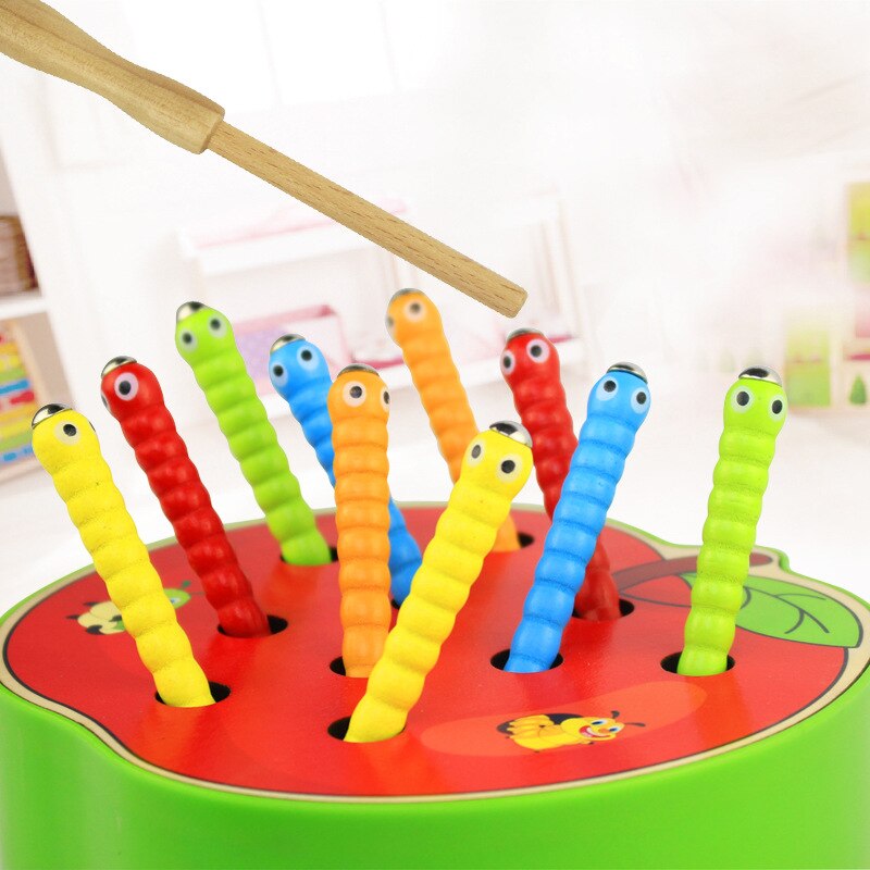 Magnetic fishing rod above colorful worms in an apple-shaped wooden base