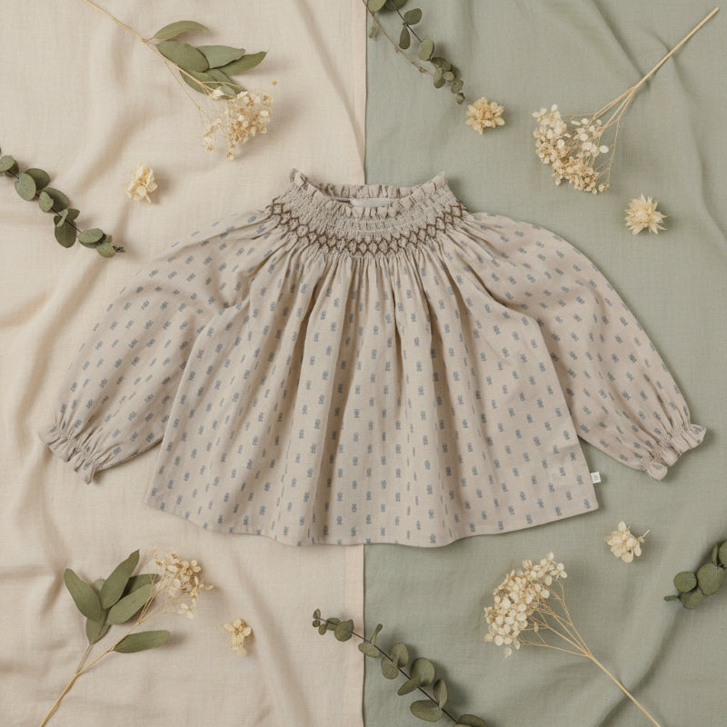 Apricot top with a small blue print and gathered neckline arranged with leaves and flowers
