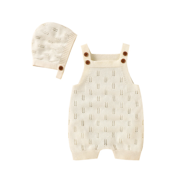 Apricot knitted baby overalls and matching hat with buttoned straps and a textured knit pattern.