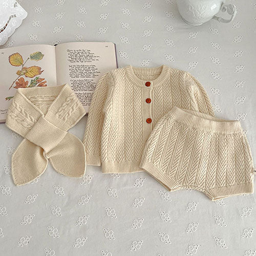 Apricot textured knit cardigan and shorts arranged beside a matching scarf