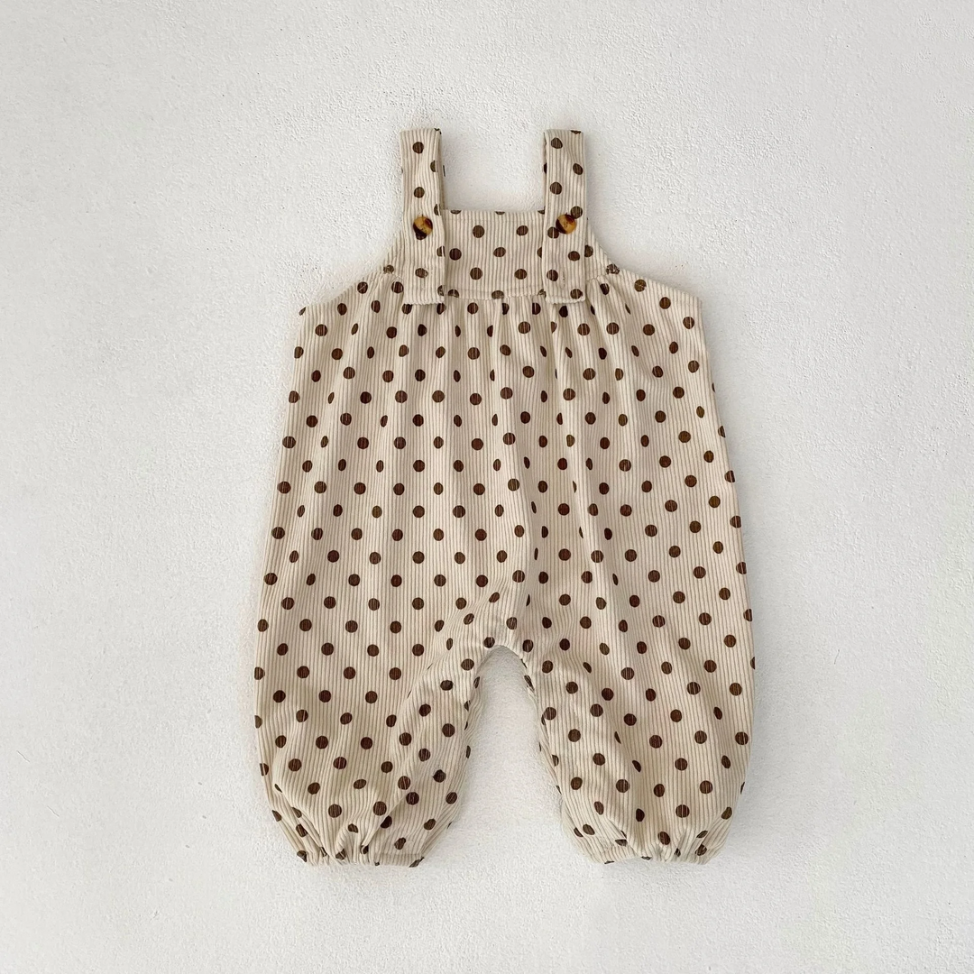 Apricot baby jumpsuit with brown polka dots, buttoned shoulder straps, and gathered ankle openings.