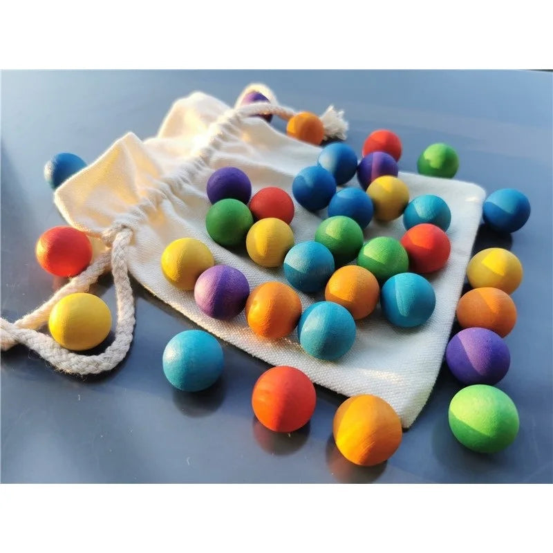 Wooden balls in assorted colors spread across a drawstring bag and tabletop