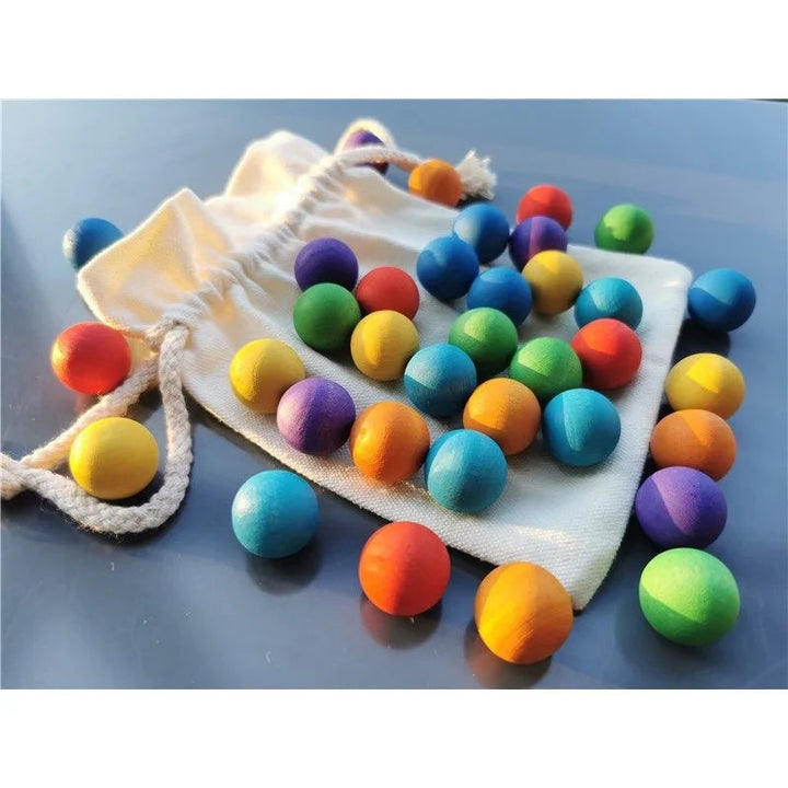 Wooden balls in assorted colors spread across a drawstring bag and tabletop