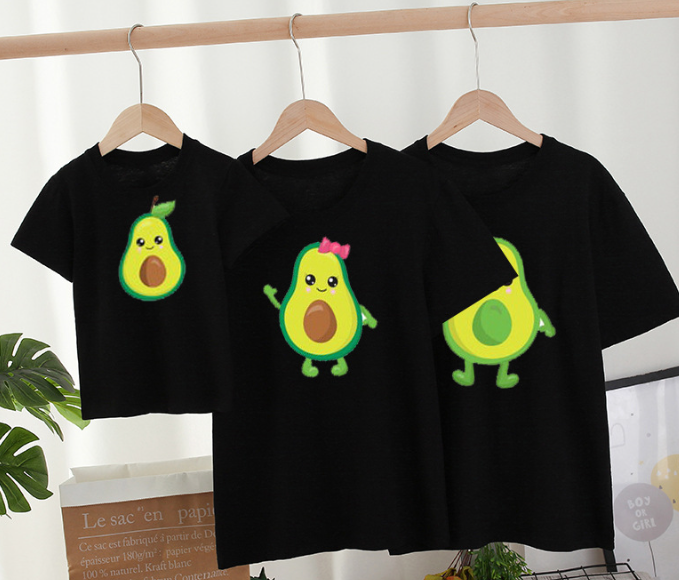 Three black family T-shirts on wooden hangers with different green avocado character prints