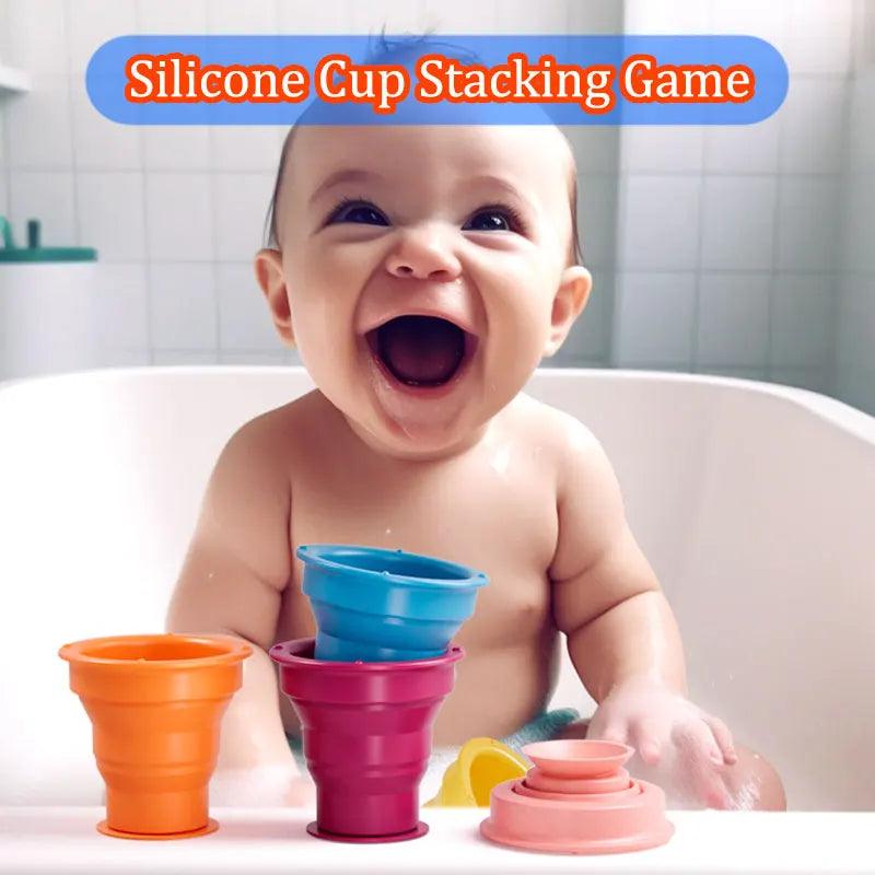 Baby in a bathtub with colorful silicone stacking cups along the edge