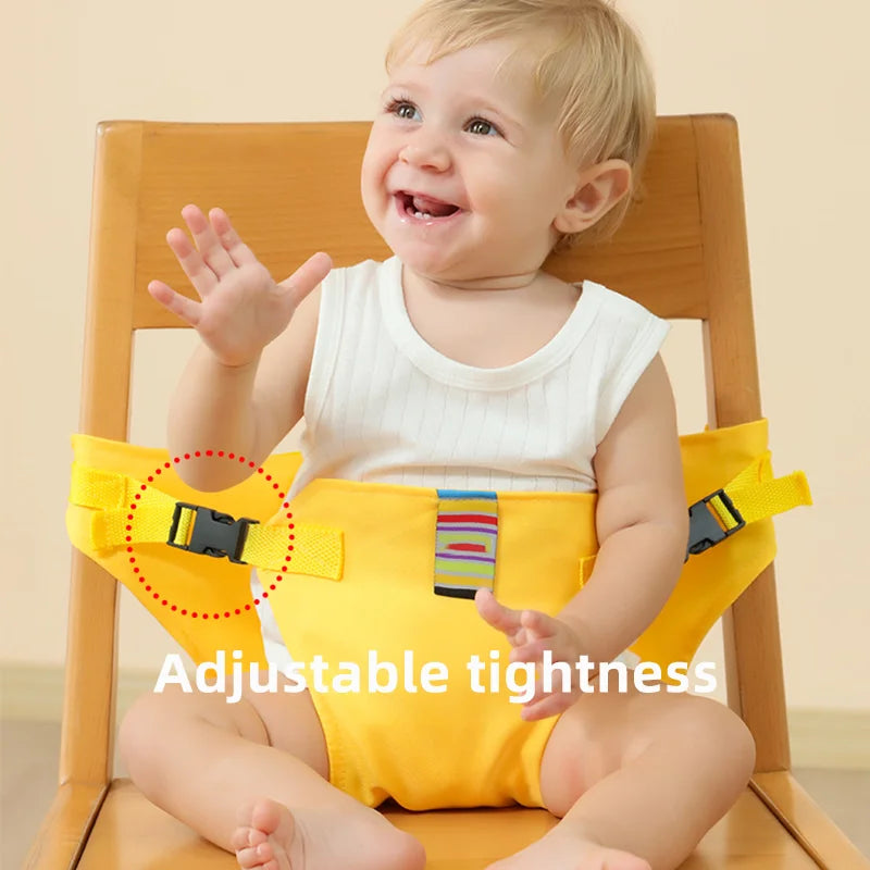Child in a yellow chair harness with the side adjustment buckle highlighted.