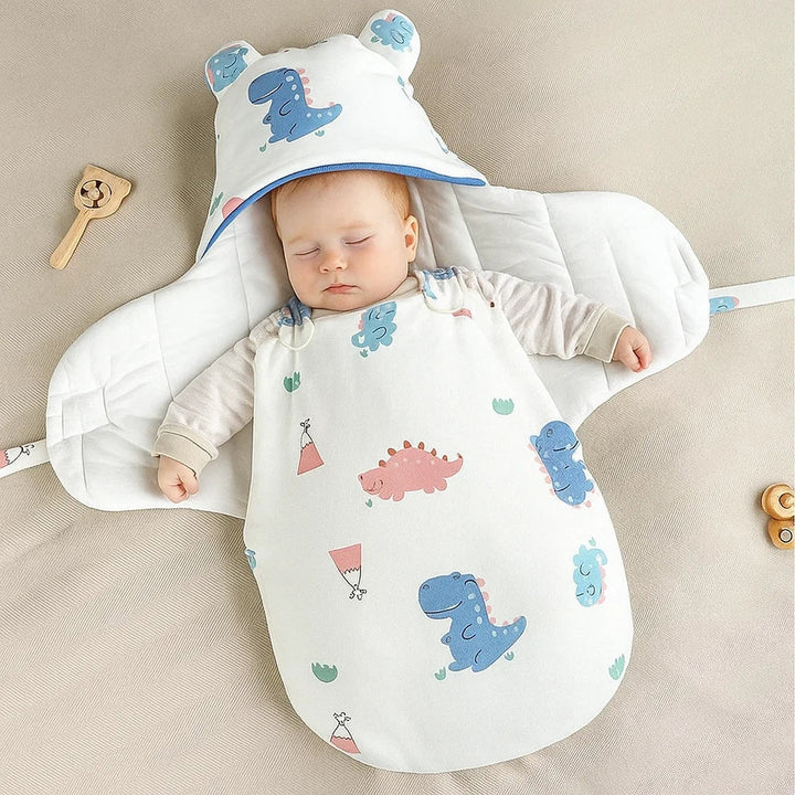 Baby resting in a dinosaur-print swaddle blanket with the side panels open