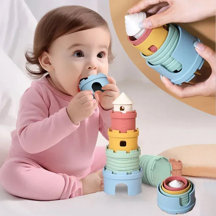 Baby exploring a blue castle cup beside stacked and nested silicone pieces