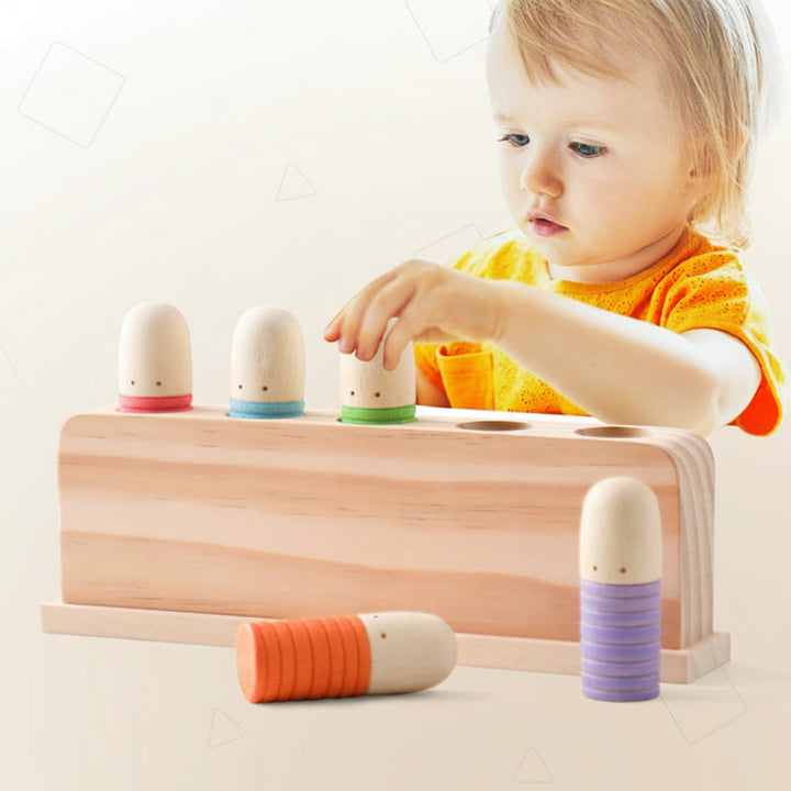 Baby reaching for a colorful peg on a wooden sensory toy