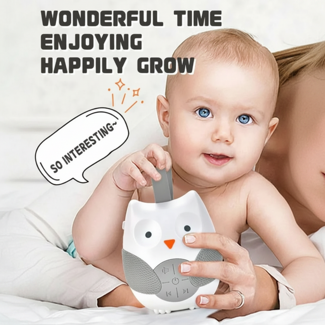 Baby holding the owl sound machine by its gray loop strap.