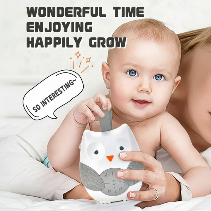 Baby holding the owl sound machine by its gray loop strap.