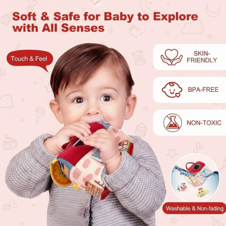 Baby holding the soft farmhouse toy by its red fabric roof