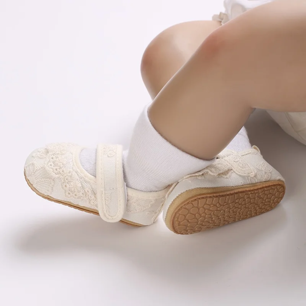 Baby wearing lace shoes and white socks, with one rubber sole visible