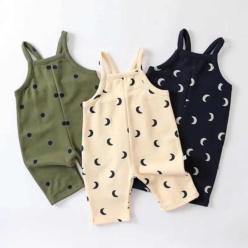 Olive dotted, cream crescent-moon and navy crescent-moon baby overalls arranged together