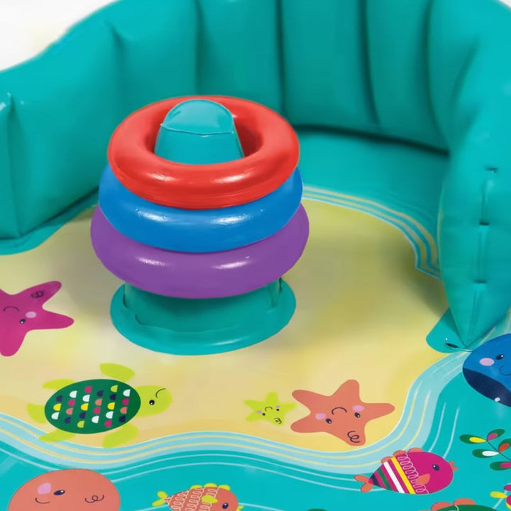 Three colorful stacking rings on the center post of an ocean-themed baby pool