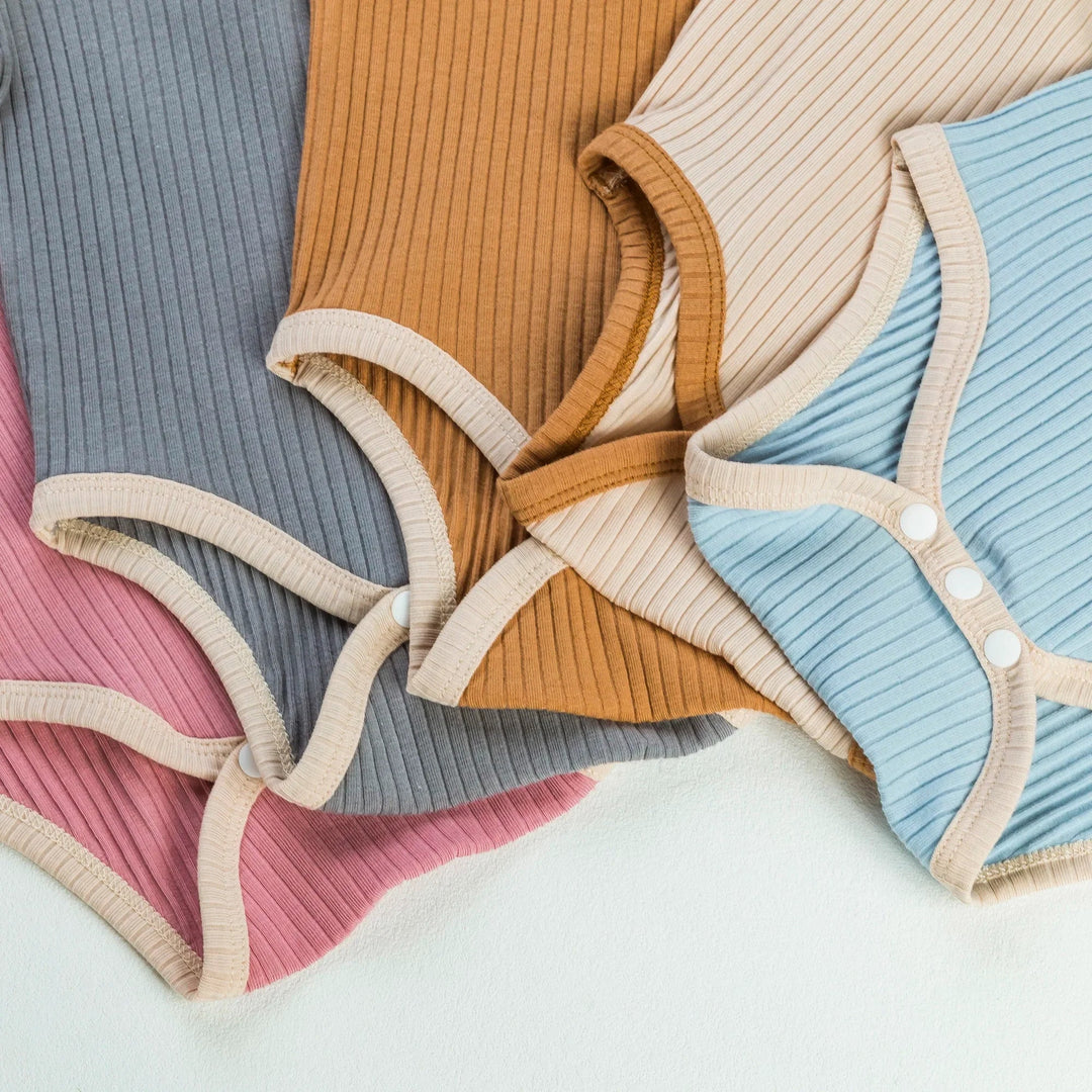 Bottom snap closures and contrast leg trim on ribbed baby rompers