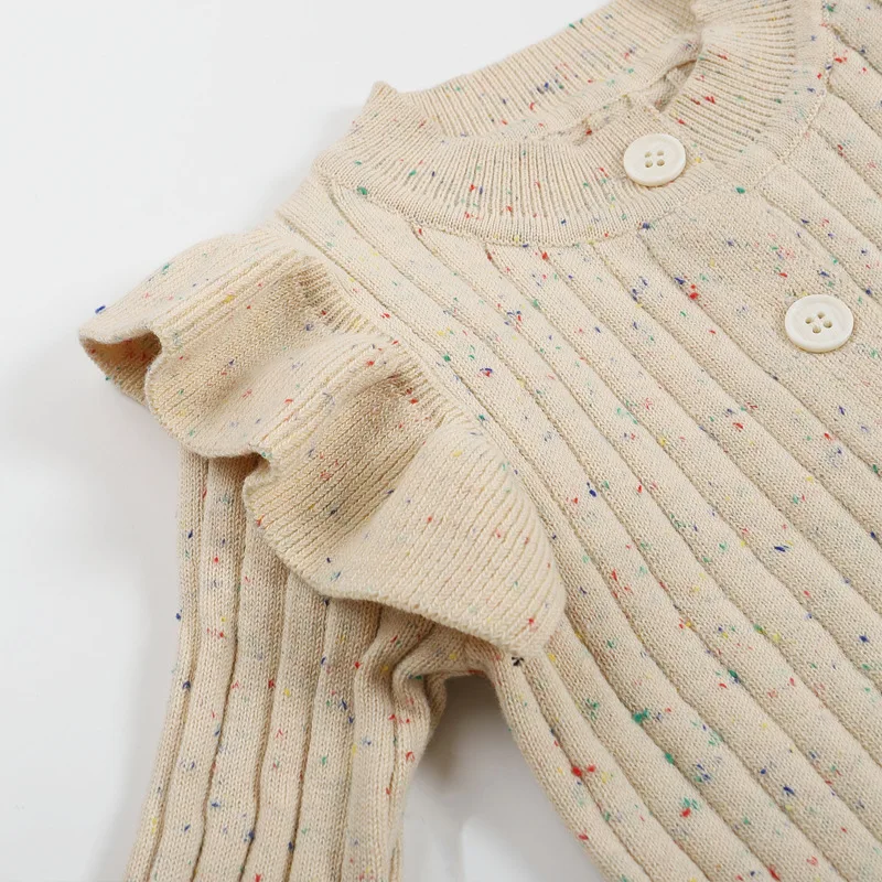 Close-up of a ruffled shoulder and ribbed knit with tiny color flecks