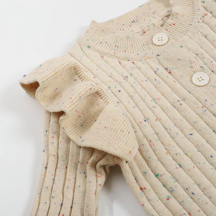 Close-up of a ruffled shoulder and ribbed knit with tiny color flecks