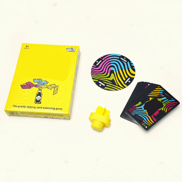Balance game set with a yellow box, slotted cards, colorful disc, and yellow bottle stopper.