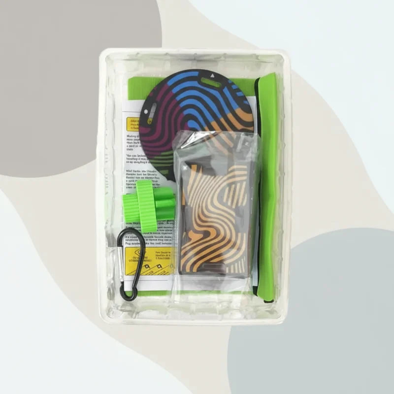 Open tray with colorful cards, a round balancing platform, and green game components.