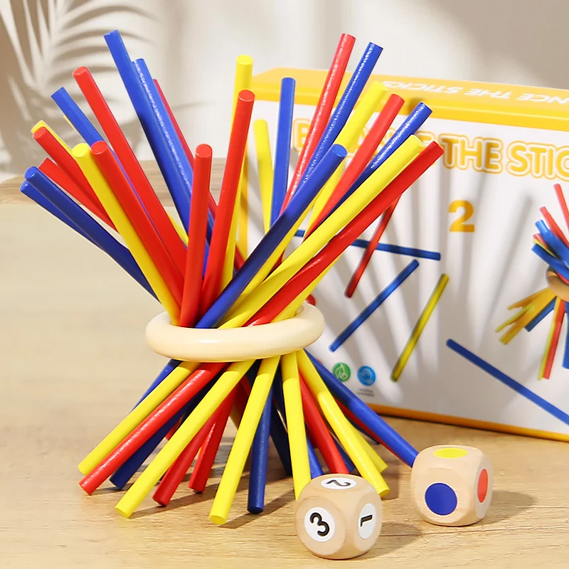 Colorful sticks balanced through a wooden ring with a numbered die and a color die.
