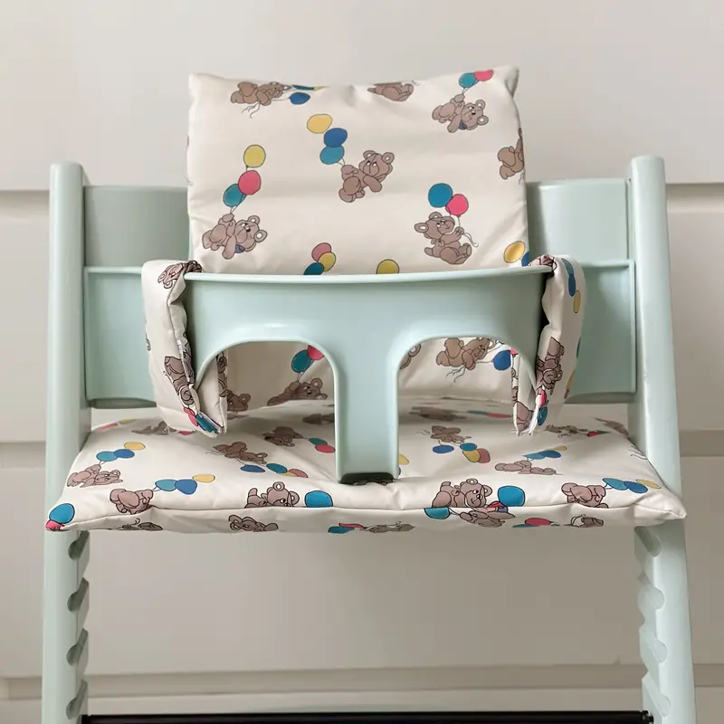 Balloon-bear patterned seat, backrest, and side padding on a mint-green high chair