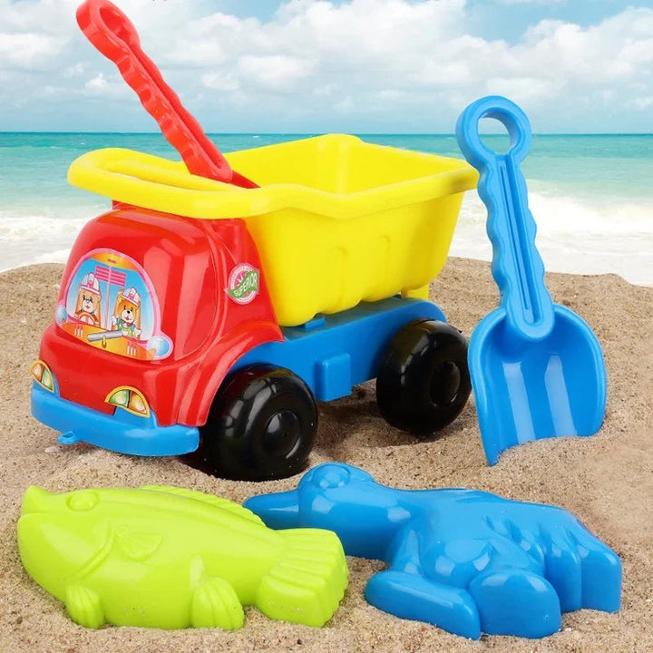 Colorful sand toy set with a dump truck, rake, shovel, and two animal molds on the beach.