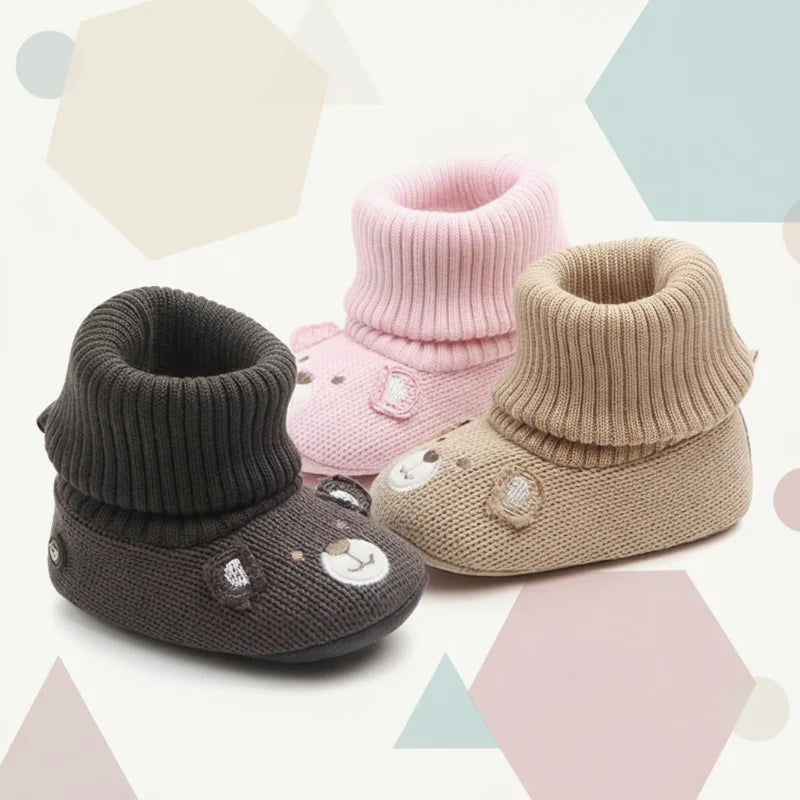 Dark gray, pink and beige knit baby booties with ribbed cuffs and bear faces.