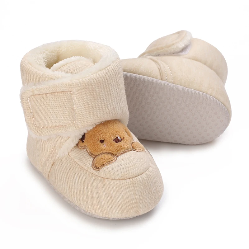 Beige bear baby boots with one shoe turned to show the textured outsole