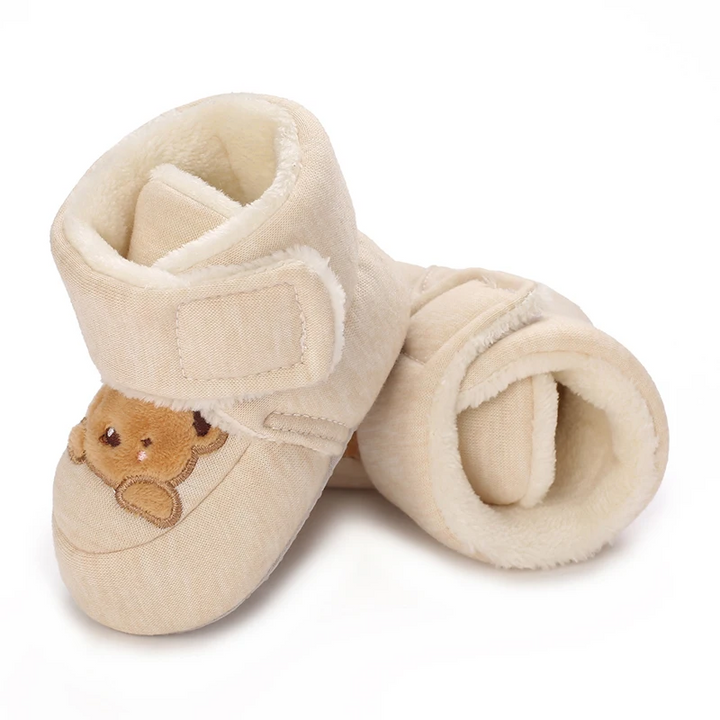 Beige bear baby shoes positioned to show the soft lining and foot openings