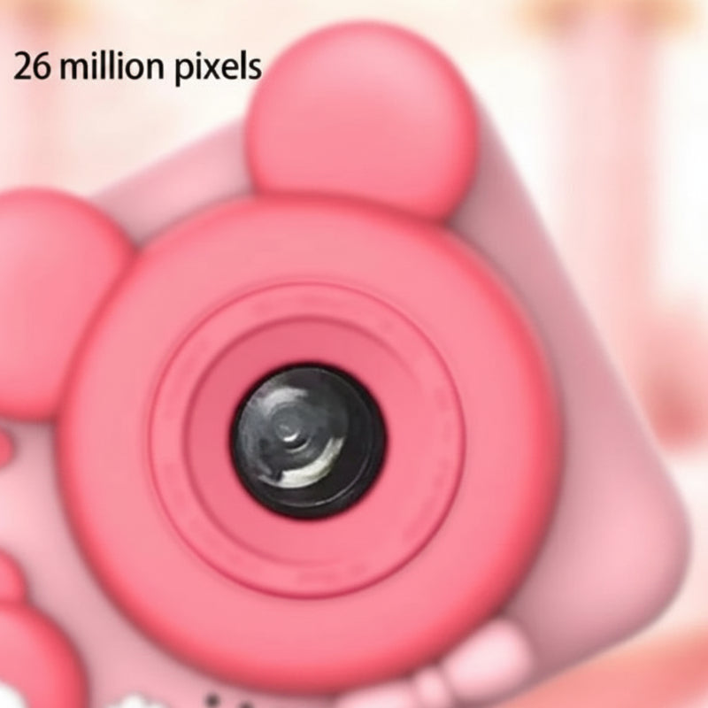 Close-up of the front lens and rounded bear ears on the pink digital camera