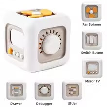 Beige and white activity cube showing a flower spinner, large dial, switches, sliders, and drawer