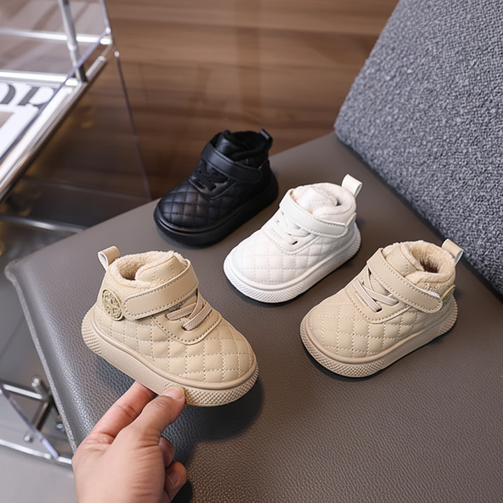 Beige quilted ankle boot held beside white, beige and black boots on a chair