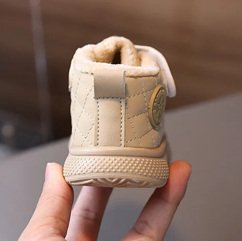 Rear view of a beige ankle boot with a plush collar and pull tab