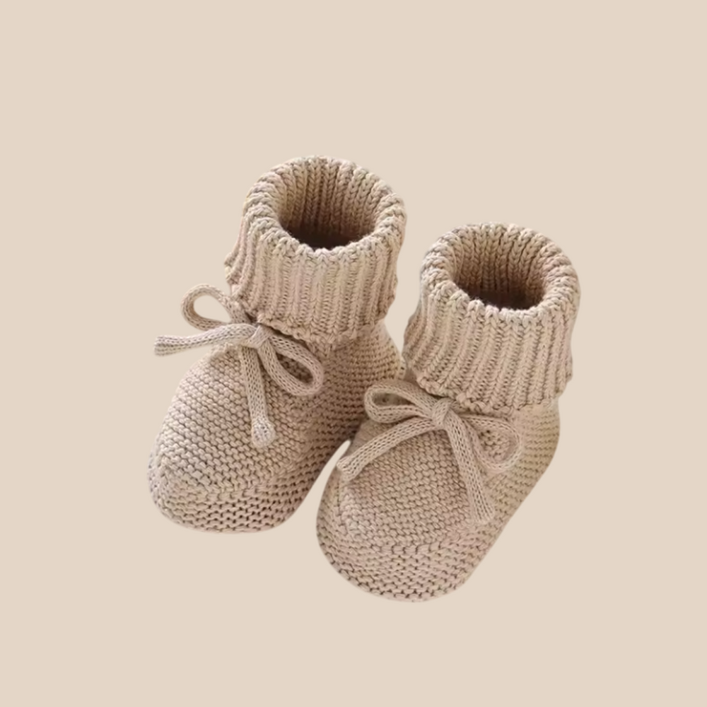 Pair of beige knit baby booties with matching front ties