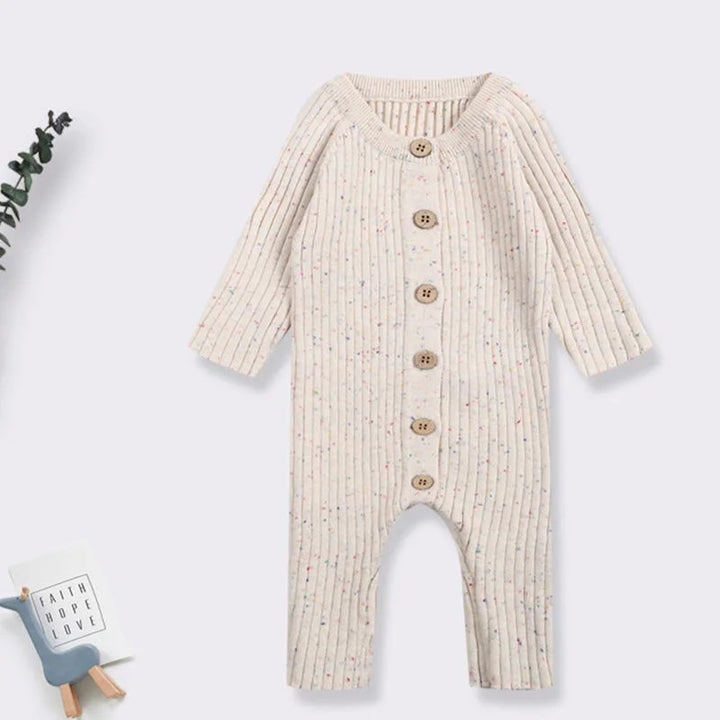 Beige cotton-knit baby romper laid flat with long sleeves and a button front