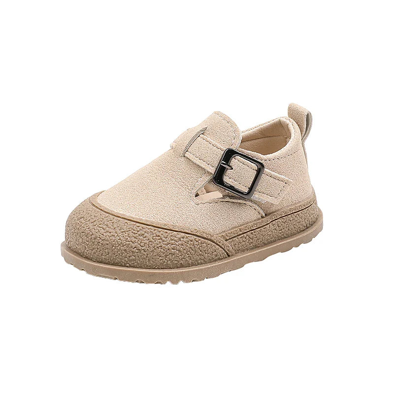Side view of a beige baby shoe with a buckle detail and textured sole edge
